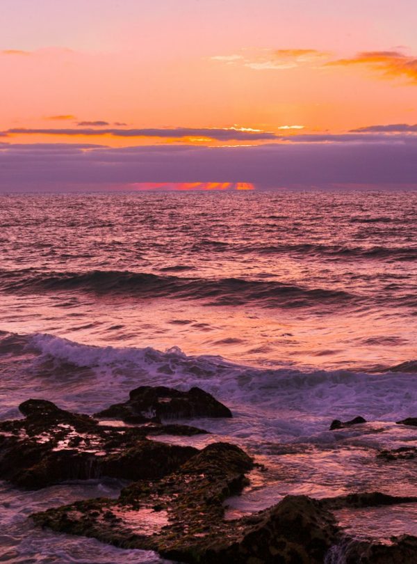 ocean waves crashing on rocks during sunset